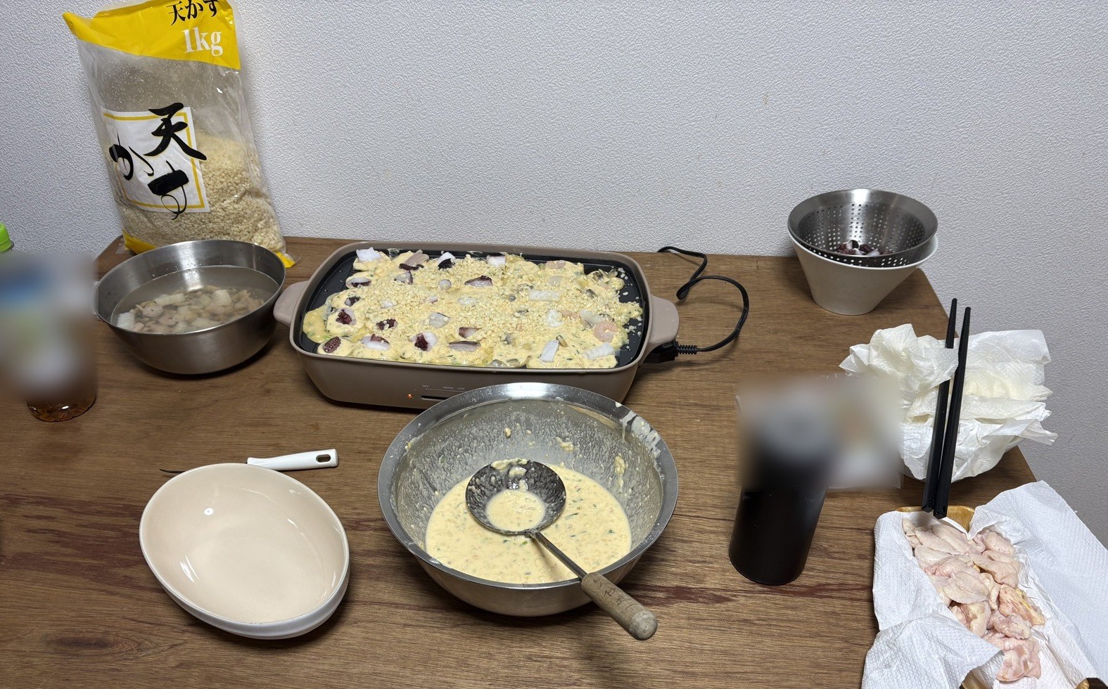 ホットプレートに並べた焼く前のたこ焼き（タコ・シーフードミックス・天かす）と、鶏のぼんじり